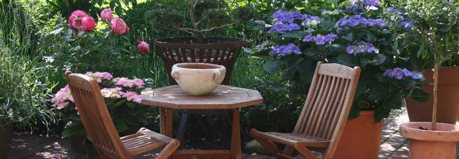 Sitzecke im Garten mit blühenden Blumen